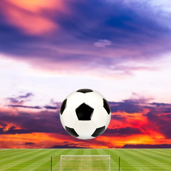 Soccer ball with soccer field against beautiful sunset — Stock Photo, Image