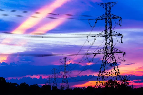 Energii elektrycznej filarów przeciwko kolorowy zachód słońca — Zdjęcie stockowe