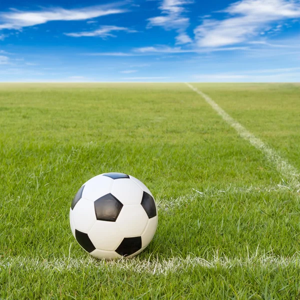 Soccer ball on soccer field against blue sky — Stock Photo, Image