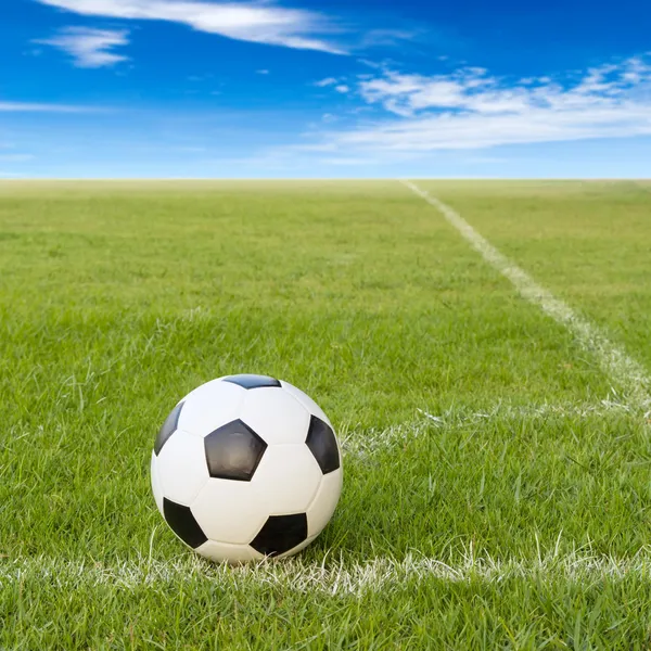 Pallone da calcio sul campo di calcio contro il cielo blu — Foto Stock