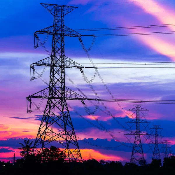 Energii elektrycznej filarów przeciwko kolorowy zachód słońca — Zdjęcie stockowe