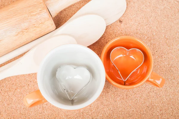 Ceramic cups with cookies cutter on cooking table — Stock Photo, Image