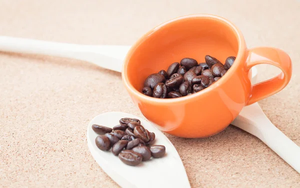 Kaffeebohnen in Keramiktasse und Holzlöffel — Stockfoto