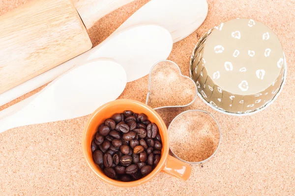 杯のコーヒー豆とテーブルの上のパン屋装置 — ストック写真