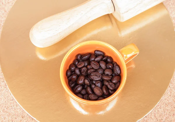 Pražená zrnková káva v šálku na stůl — Stock fotografie