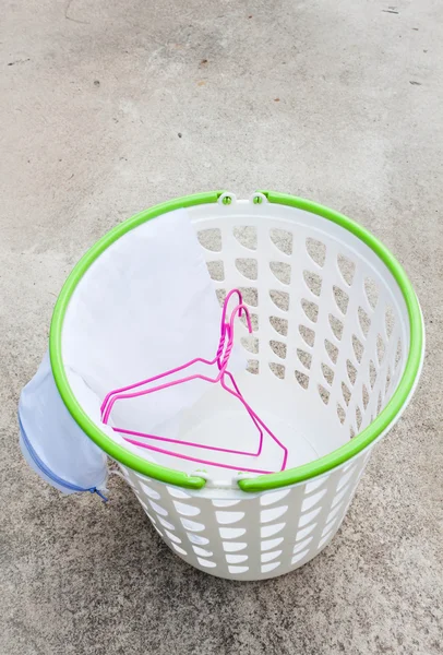 Cloth hanger and wash bag in plastic laundry basket — Stock Photo, Image