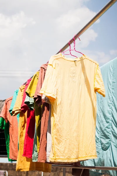 Colorful clothing drying on clothesline under sunlight — Stock Photo, Image