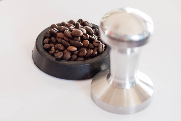 Aluminum tamper and roasted coffee bean for barista