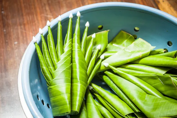 Handgjorda banana leaf ris erbjuder på bord av trä — Stockfoto