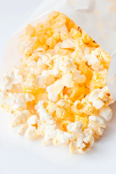 Fresh butter popcorn falling out of paper pack — Stock Photo, Image