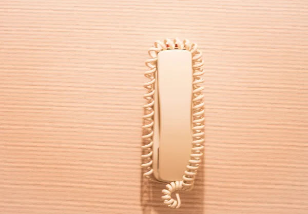 Stand by toilet hanging telephone on warm white background