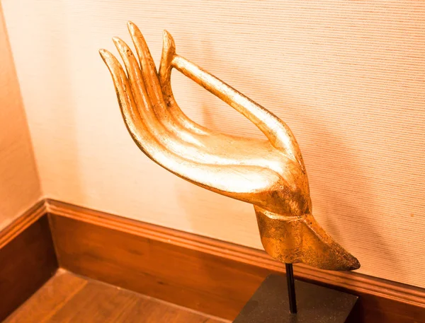 Gold wood carved hand sculpture on wood table — Stock Photo, Image