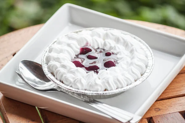 Torta de queijo de mirtilos com chantilly na mesa de madeira — Fotografia de Stock