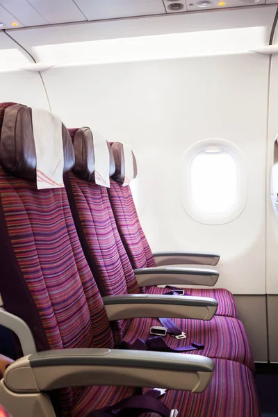 Airplane seat row in passenger cabin with window beside — Stock Photo, Image