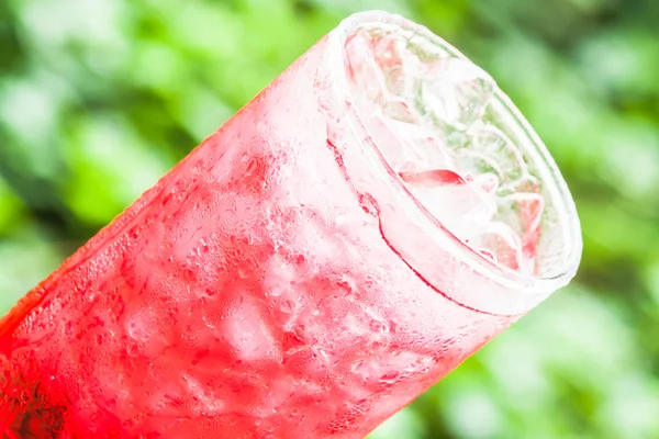 Kaltes Glas süßes rotes Getränk mit Eiswürfeln — Stockfoto