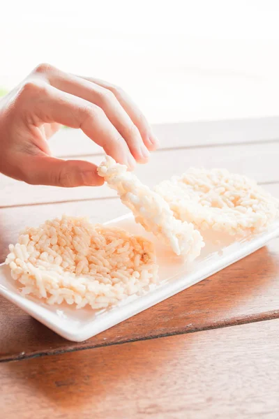 Hand on thai style crispy rice cracker — Stock Photo, Image