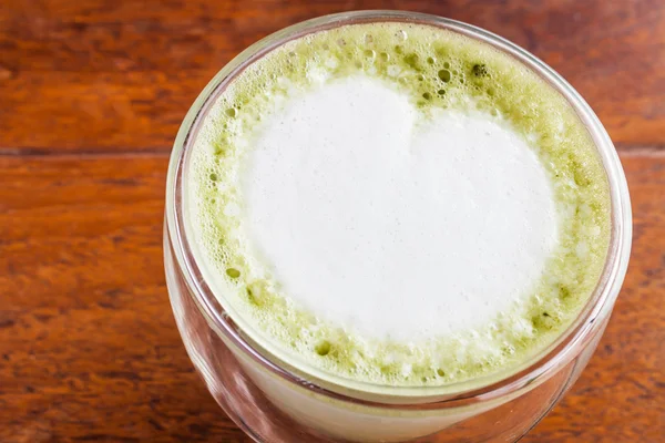 Matcha grönt te latte som tjänstgör på bord av trä — Stockfoto