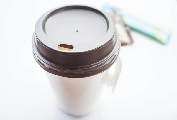 Varm kaffe i papirkop med sukkerpakker på hvid baggrund - Stock-foto