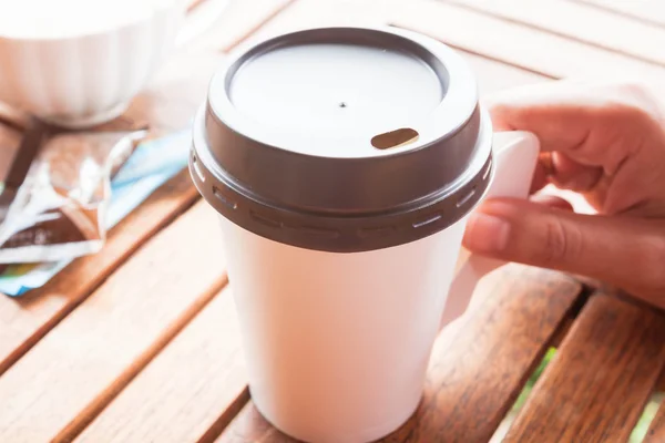 Hett kaffe i papper kopp servering på bord av trä — Stockfoto