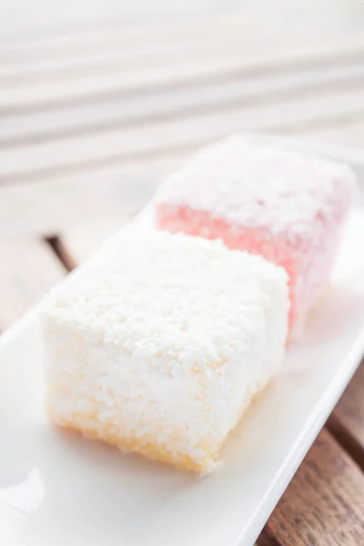 Pink and white lamington cakes on wood table — Stock Photo, Image