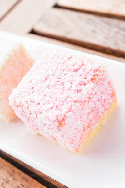 Pink lamington cakes up close on wood table — Stock Photo, Image