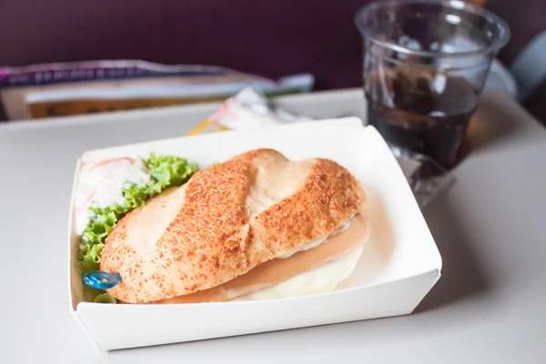 Eenvoudige maaltijd met worst Hamburger geserveerd op het vliegtuig — Stockfoto