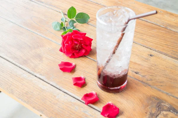 Rosa roja y bebida de granada fría en la mesa de madera — Foto de Stock