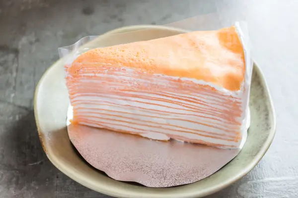Piece of homemade orange crepe cake — Stock Photo, Image