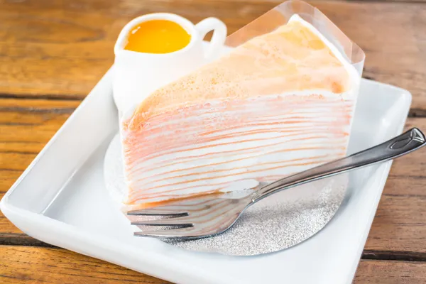 Delicioso bolo de crepe laranja servindo no prato — Fotografia de Stock