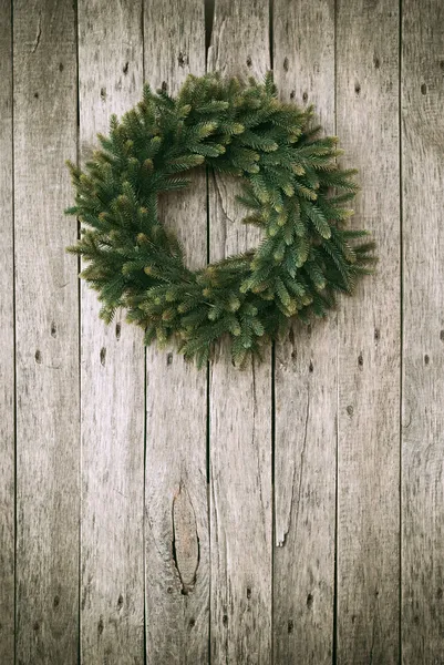 Πράσινο στεφάνι Χριστουγέννων σε ξύλινο φόντο — Φωτογραφία Αρχείου