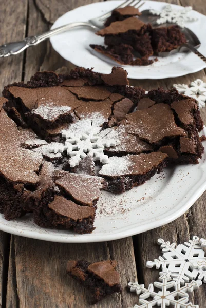 Die gebackene knusprige Schokolade, die mit einer Schneeflocke und Puder verziert ist — Stockfoto