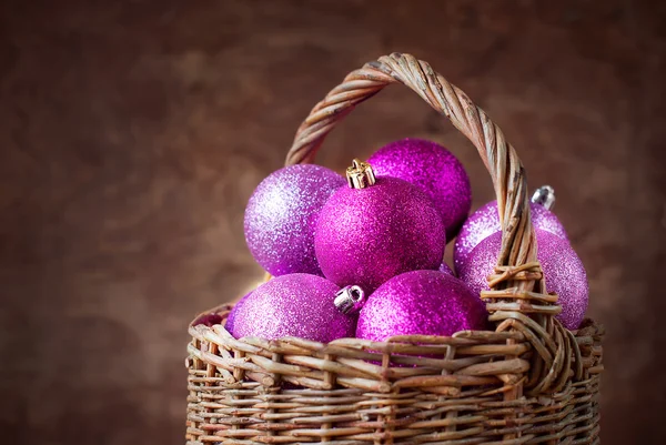 Lysande rosa julgranskulor i en korg — Stockfoto