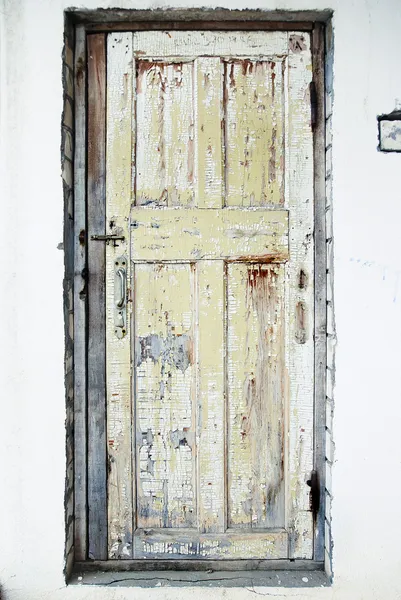 ひびの入ったペイントの背景を持つ壁の古いドア — ストック写真