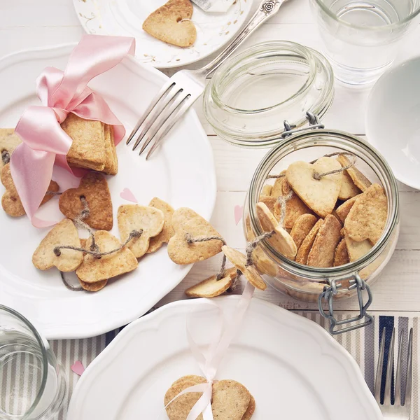 Galletas en forma de corazón sobre una mesa de madera blanca —  Fotos de Stock