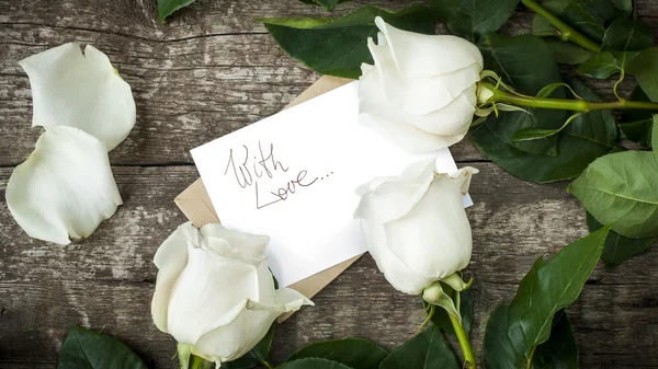 Άσπρα τριαντάφυλλα με απομονωμένες επιστολή στο τραπέζι — Φωτογραφία Αρχείου