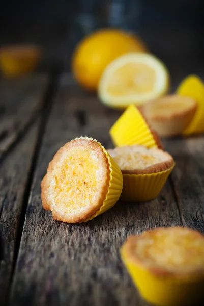 Лимонные тартлеты в желтых раковинах на деревянном столе — стоковое фото