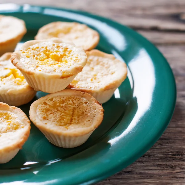 Tartlets de limão em uma placa verde, fundo de madeira — Fotografia de Stock