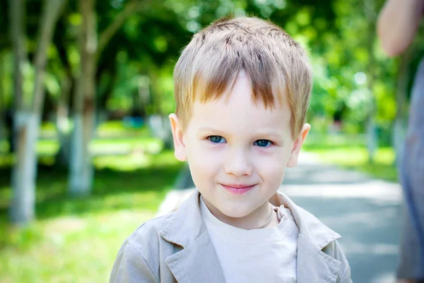 Happy Smiling Boy aux yeux bleus et aux cheveux blonds dans le parc — Photo