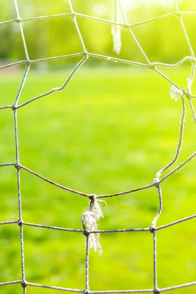 Het gat op een oude voetbal raster van poort, achtergrond — Stockfoto