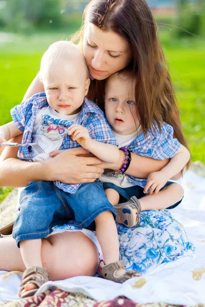 Jonge moeder kan niet rustig de haar tweeling, in een park — Stockfoto