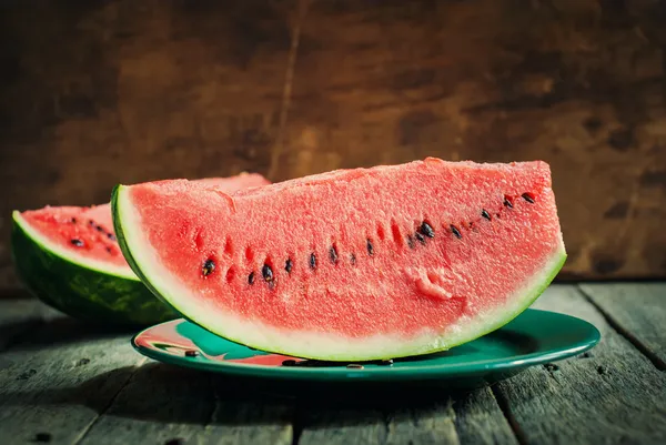 A Slice of Water-melon on a plate, wooden background — Stock Photo, Image