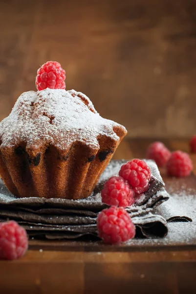 Fruitcake versierd met framboos aan de houten tafel — Stockfoto