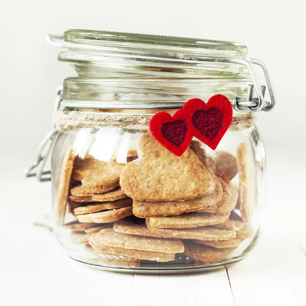 A cookie-k a jar, díszített két piros szívek — Stock Fotó