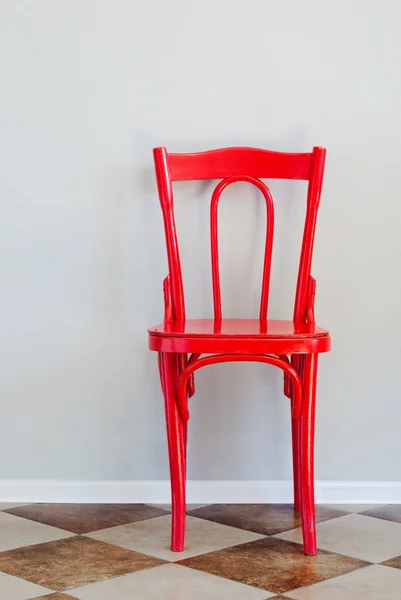 Красное кресло на серой стене — стоковое фото