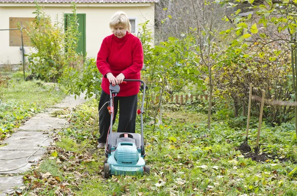 Vrouw maait gras grasmaaier — Stockfoto