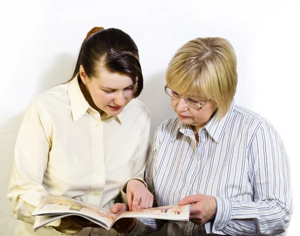 Two women read a fashion magazine — Stock Photo, Image