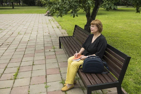 Vrouw wil werken deuk zitten in het park in een lunchpauze — Stockfoto