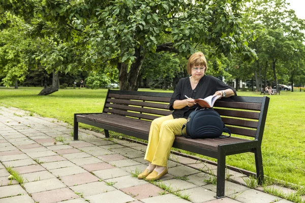 Žena plánuje pracovat dent sedí v parku na přestávku na oběd — Stock fotografie