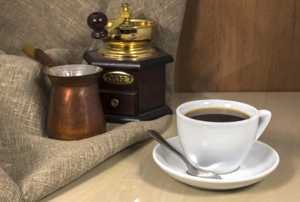 Káva v šálku na mramorový stůl, ruka mlýn a cezve — Stock fotografie