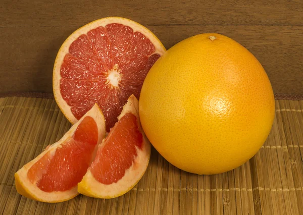 Grapefruit. Whole fruit and slices are on the table — Stock Photo, Image